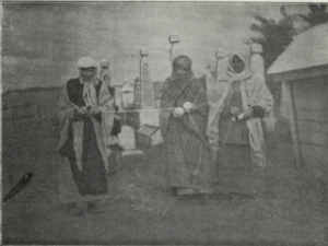 Three feldmesterins in a black and white photo are walking and measuring a grave